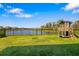 Well-manicured backyard with a play set and fenced-in yard, offering a serene view of the adjacent lake at 12730 Oak Hill Way, Parrish, FL 34219