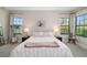 Bright bedroom featuring two windows, stylish lamps, and neutral decor at 12730 Oak Hill Way, Parrish, FL 34219