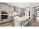 Modern kitchen with stainless steel appliances, an island with seating and gray cabinets at 12730 Oak Hill Way, Parrish, FL 34219