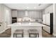 Modern kitchen with an island with seating, gray cabinets, and stainless steel appliances at 12730 Oak Hill Way, Parrish, FL 34219