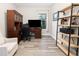 Bright office space with wood-look floors, built-in shelving, and traditional wood desk and bookcase at 12730 Oak Hill Way, Parrish, FL 34219