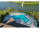 Stunning aerial view of an inviting community pool with ample seating, adjacent to a beautiful lake with fountain at 12730 Oak Hill Way, Parrish, FL 34219