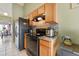 Functional kitchen with stainless steel appliances, wood cabinets and tile flooring at 13191 Siam Dr, Spring Hill, FL 34609