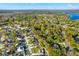 Aerial view of a neighborhood with tree-lined streets and a view of a lake in the distance at 13911 Briardale Ln, Tampa, FL 33618