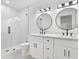 Modern bathroom featuring dual sinks with round mirrors and a glass enclosed shower at 13911 Briardale Ln, Tampa, FL 33618