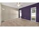 Bedroom with neutral carpet, purple accent wall and lots of light through large windows at 13911 Briardale Ln, Tampa, FL 33618