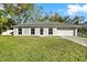 Inviting single-story home with a two-car garage, mature landscaping, and a well-maintained lawn at 13911 Briardale Ln, Tampa, FL 33618