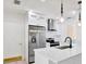 Bright kitchen features stainless steel appliances, white cabinetry, and a quartz countertop island with pendant lighting at 13911 Briardale Ln, Tampa, FL 33618