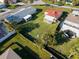 Large grassy backyard featuring an outdoor patio area, surrounded by lush greenery and fencing at 15822 Redington Dr, Redington Beach, FL 33708