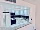 Bright kitchen with white cabinets, granite countertops, and black backsplash at 1620 58Th Ave. S. # 1, St Petersburg, FL 33712