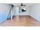 Bright living room with wood floors, a staircase, and a glimpse of the modern kitchen with stainless steel appliances at 1620 58Th Ave. S. # 1, St Petersburg, FL 33712