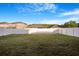 Lush backyard with a green lawn, framed by a pristine white fence at 20427 Carolina Cherry Ct, Tampa, FL 33647