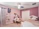 Cozy bedroom with pink walls, white furniture, and a window providing natural light at 20427 Carolina Cherry Ct, Tampa, FL 33647