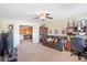 Open-concept living room featuring a couch, desk, ceiling fan, and plenty of space at 20427 Carolina Cherry Ct, Tampa, FL 33647