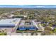 Aerial view of the condo, illustrating its location among lush greenery and nearby commercial buildings at 215 Valencia Blvd # 205, Belleair Bluffs, FL 33770