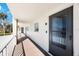 Hallway leading to unit featuring a modern entry door, exterior railing, and an entry buzzer at 215 Valencia Blvd # 205, Belleair Bluffs, FL 33770
