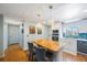 Bright remodeled kitchen with an eat-in island, stainless appliances, and modern light fixtures at 215 Valencia Blvd # 205, Belleair Bluffs, FL 33770