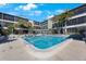 Relaxing community pool surrounded by lush landscaping at this condo complex with lounge chairs at 215 Valencia Blvd # 205, Belleair Bluffs, FL 33770