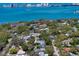 Aerial view of a coastal community with waterfront views and a mix of homes and trees at 217 Manatee Rd, Belleair, FL 33756