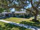 Charming home with mature landscaping, driveway, and covered garage on a sunny day at 217 Manatee Rd, Belleair, FL 33756