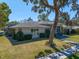 Beautifully landscaped single-story home with manicured lawn and gray stone accents at 217 Manatee Rd, Belleair, FL 33756