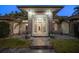 An inviting front entrance with custom stone columns, decorative plants, and statement lighting at 217 Manatee Rd, Belleair, FL 33756