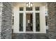 Beautiful entryway featuring a stone facade, modern lighting, and glass windows for a bright, welcoming feel at 217 Manatee Rd, Belleair, FL 33756