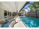 Inviting screened pool area with elegant chaise lounges offers a perfect spot to relax and enjoy the Florida sunshine at 217 Manatee Rd, Belleair, FL 33756