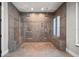 Spacious walk-in shower with dual shower heads, tile surround, pebble floor, and glass enclosure at 217 Manatee Rd, Belleair, FL 33756