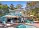 Charming backyard with a tiki bar, pool, and upper-level deck, creating an inviting outdoor entertainment space at 235 Aberdeen St, Dunedin, FL 34698