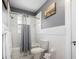 Classic white-tiled bathroom featuring a shower-tub combo and monochrome mosaic tile flooring at 235 Aberdeen St, Dunedin, FL 34698