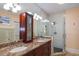 Bathroom featuring double sinks, granite countertops, and walk-in shower with glass door at 235 Aberdeen St, Dunedin, FL 34698