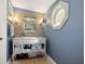 Bathroom with tiled walls, unique lighting, and an octagonal window above vanity at 235 Aberdeen St, Dunedin, FL 34698