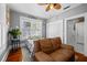 Comfortable bedroom with a ceiling fan, two windows, closet space, and a cozy couch for relaxing at 235 Aberdeen St, Dunedin, FL 34698