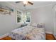 Relaxing bedroom featuring coastal-themed decor, two windows with blinds, and a comfortable bed at 235 Aberdeen St, Dunedin, FL 34698