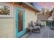 Inviting deck with outdoor seating, a blue entry door, and string lights offering a cozy space for relaxation at 235 Aberdeen St, Dunedin, FL 34698