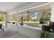 Inviting front porch with plants and view of the neighborhood's mature trees at 235 Aberdeen St, Dunedin, FL 34698