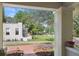 View from the front porch, showing the lush green lawn and landscaping around the property at 235 Aberdeen St, Dunedin, FL 34698