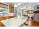 Bright kitchen with a large island with striking marble countertop, wood cabinets, and a view of the dining area at 235 Aberdeen St, Dunedin, FL 34698
