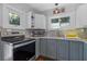 Charming kitchen with white and blue cabinets, granite counters, and stainless steel appliances at 235 Aberdeen St, Dunedin, FL 34698