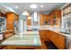 Spacious kitchen featuring a large island with a striking green marble countertop, stainless steel appliances and wood cabinetry at 235 Aberdeen St, Dunedin, FL 34698