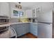 Charming kitchen with white and blue cabinets, granite counters, and stainless steel appliances at 235 Aberdeen St, Dunedin, FL 34698