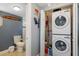 Convenient laundry area featuring a stacked washer and dryer unit adjacent to a full bathroom at 235 Aberdeen St, Dunedin, FL 34698