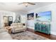 Open-concept living room with hardwood floors, bright furniture, and a large TV at 235 Aberdeen St, Dunedin, FL 34698