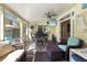 Cozy screened-in patio with comfortable seating, ceiling fan, and a TV, perfect for relaxation and entertainment at 235 Aberdeen St, Dunedin, FL 34698