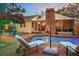 Backyard pool featuring lounge chairs, outdoor seating, a covered patio, and lush tropical landscaping at 235 Aberdeen St, Dunedin, FL 34698