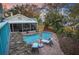 Aerial view of a private pool and patio area featuring outdoor seating and manicured landscaping at 235 Aberdeen St, Dunedin, FL 34698