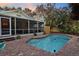 Backyard pool with a screened porch and lounge furniture, ideal for outdoor living and entertaining at 235 Aberdeen St, Dunedin, FL 34698