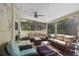 Comfortable screened porch with ample seating, ceiling fan, and views of the lush greenery at 235 Aberdeen St, Dunedin, FL 34698