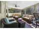Comfortable screened porch with ample seating, ceiling fan, and views of the lush greenery at 235 Aberdeen St, Dunedin, FL 34698